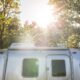 The Sun Shining Down on a Small Airstream Trailer Parked in the Woods