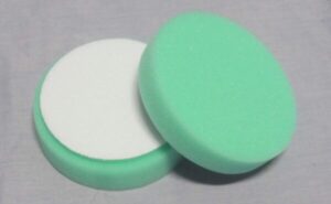 Two Polishing Pads Lying Face Up and Down on a Surface